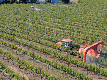 tractor-agricola-rociando-pesticidas-insecticidas-herbicidas-sobre-campo-vinedos-verdes-napa-valley_571748-2635