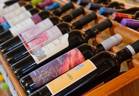 colorful wine bottles displayed on wooden rack