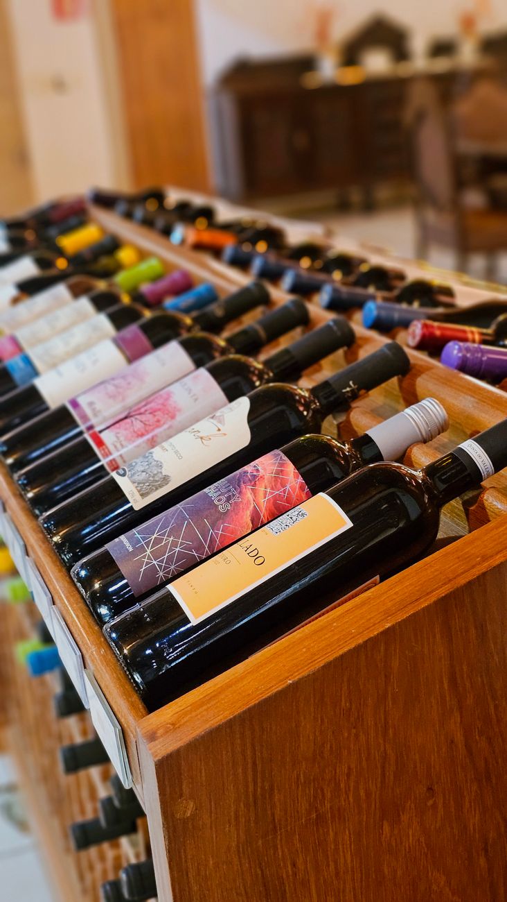 colorful wine bottles displayed on wooden rack
