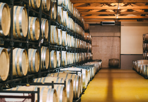 Wood wine barrels stored in a winery on the fermentation process